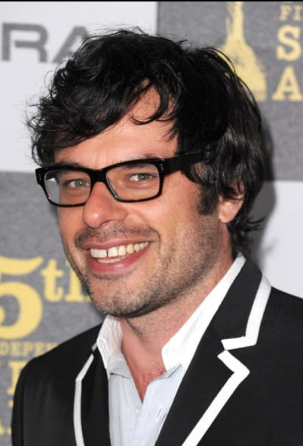 A picture of Jemaine Clement, a man with black hair, short beard and black glasses. Picture taken from:https://www.imdb.com/name/nm1318596/?ref_=tt_cl_t_1