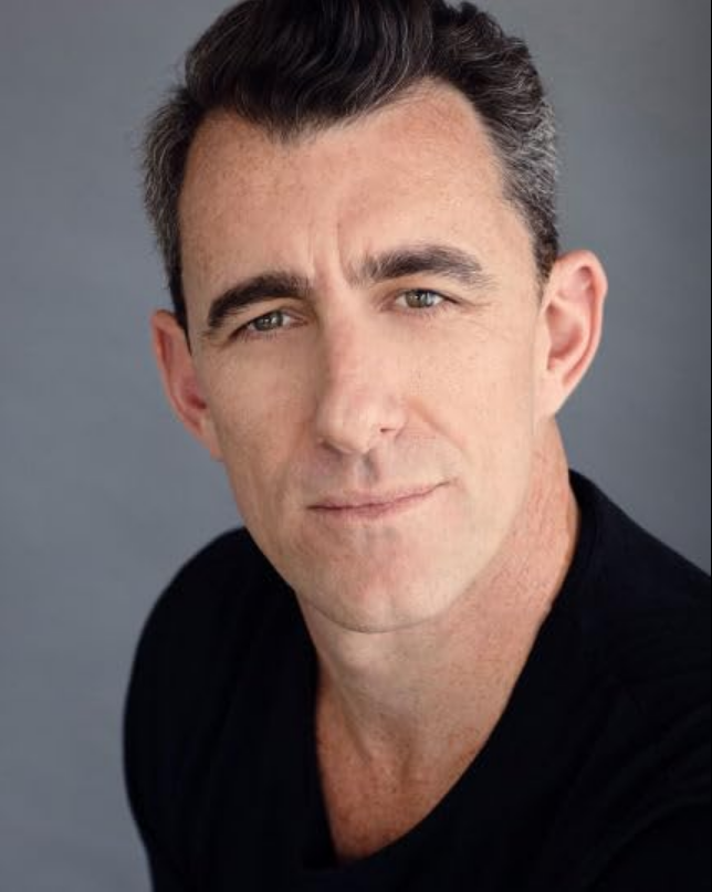 A picture of Mike Minogue, a man with short dark hair and clean shaven beard. Picture taken from:https://www.imdb.com/name/nm2333404/?ref_=tt_cl_t_11