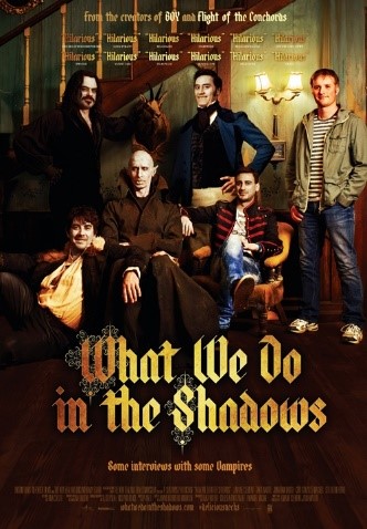 A movie poster for What we do in the Shadows, a grouop of people sitting and standing by a sofa, four men looking like old-fashioned vampires, one man looking like a modern vampie and one ordinary man standing to the far right.